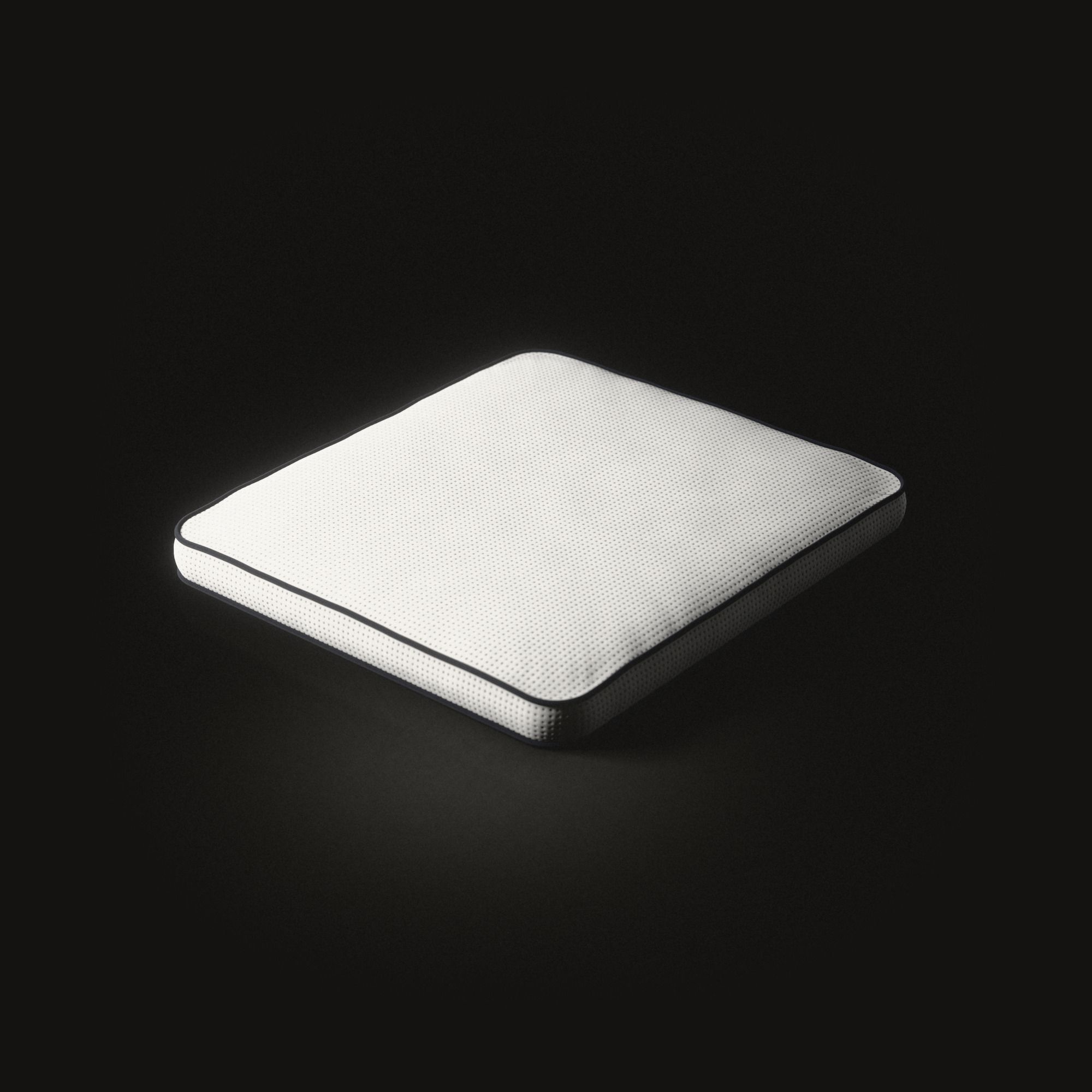 Un coussin d’assise plat et blanc aux coins arrondis sur un sol noir : un tissu tricoté à fins œillets, un cordon sombre autour du bord supérieur et un autre autour du bord inférieur.